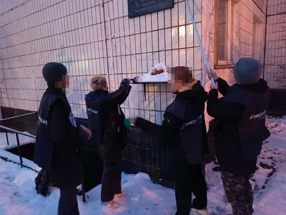 Youth Chamber members clearing snow from the memorial plaque to Hero of the Soviet Union N. D. Ivanov, 14th microdistrict, November 2024